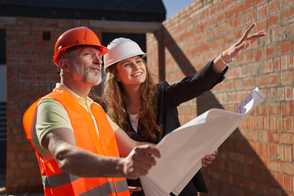 Construction Workers Discussing Blueprint at Construction Site.