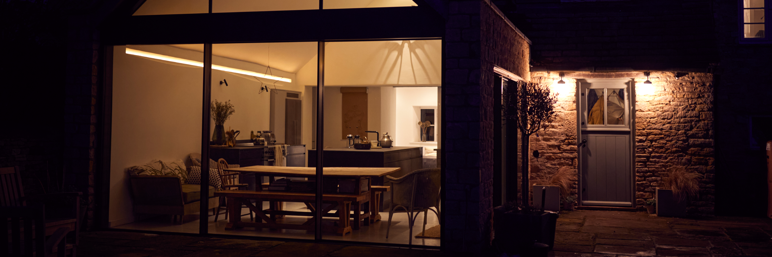 Modern Home Exterior with Stone Wall and Glass Extension